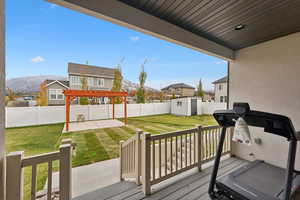 Exterior space featuring a pergola, a mountain view, a patio area, a lawn, and a storage unit