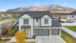 View of front of property featuring a garage, a front yard, and a mountain view