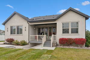 Back of house featuring covered porch and a yard