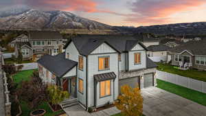 View of front of property featuring a garage, a lawn, and a mountain view