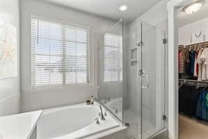 Bathroom featuring independent shower and bath, a healthy amount of sunlight, and a textured ceiling