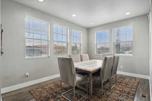 Dining space with dark wood-type flooring