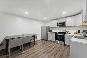 Kitchen featuring sink, wood-type flooring, and stainless steel appliances