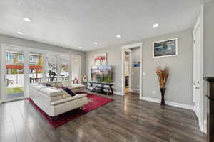 Living room featuring a textured ceiling and dark hardwood / wood-style flooring