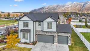 View of front of home featuring a mountain view, a garage, and a front lawn