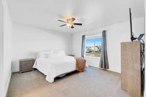 Carpeted bedroom featuring ceiling fan