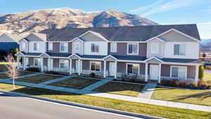 View of front of property featuring a front yard, a mountain view, and covered porch