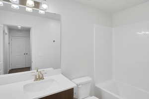 Full bathroom with vanity, toilet, and  shower combination