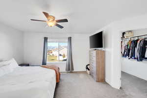 Carpeted bedroom with a closet and ceiling fan