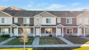 Multi unit property with a mountain view, a porch, and a front lawn