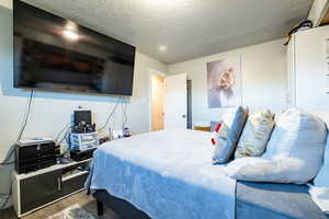 Bedroom featuring wood-type flooring and a textured ceiling