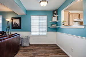 Interior space with dark hardwood / wood-style flooring and ornamental molding