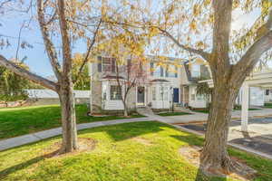 View of front of property with a front lawn and covered parking