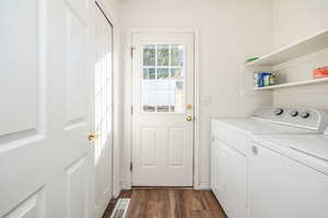 Washroom featuring washing machine and clothes dryer and dark hardwood / wood-style flooring