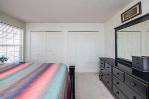 Bedroom featuring a textured ceiling and two closets