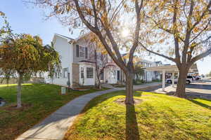 View of front of house featuring a front lawn and covered parking