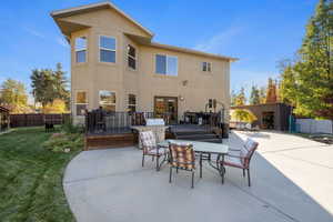 Rear view of house with a lawn and a patio