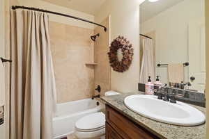 Full bathroom with shower / bath combo with  vanity, and toilet