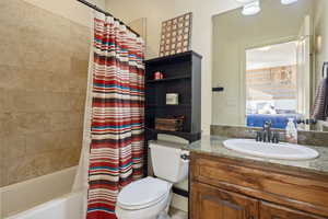 Full bathroom with vanity, shower / bath combination, and toilet