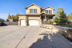 View of front facade featuring a garage enormous driveway.