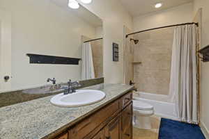 Full bathroom with toilet, vanity, tile  and shower / bathtub combination