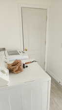 Interior space featuring independent washer and dryer and light wood-type flooring