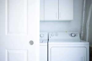 Washroom featuring cabinets and independent washer and dryer