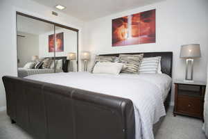 Carpeted bedroom featuring a closet