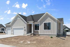 View of front of home featuring a garage and cooling unit