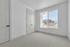 Unfurnished bedroom with a textured ceiling and light carpet