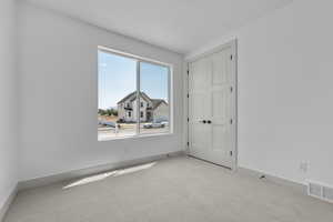 Spare room featuring light colored carpet