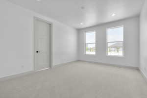 Unfurnished room with a textured ceiling and light colored carpet