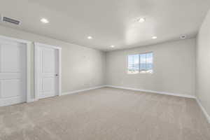 Carpeted empty room featuring a textured ceiling