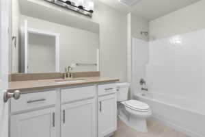 Full bathroom with toilet, vanity, tile patterned flooring, and shower / washtub combination