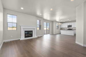 Unfurnished living room featuring dark hardwood / wood-style flooring, a chandelier, and sink