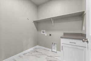 Washroom with hookup for a washing machine, electric dryer hookup, and cabinets