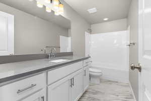 Full bathroom featuring washtub / shower combination, toilet, and vanity