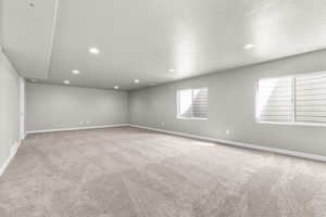 Empty room featuring a textured ceiling and light carpet