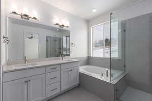 Bathroom featuring plus walk in shower, vanity, tile patterned floors, and ceiling fan