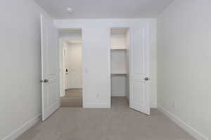 Unfurnished bedroom with a closet and light carpet