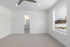 Spare room featuring light colored carpet and ceiling fan