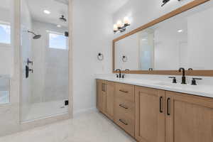 Bathroom with a wealth of natural light, vanity, and walk in shower