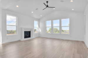 Unfurnished living room with ceiling fan, light hardwood / wood-style flooring, and vaulted ceiling