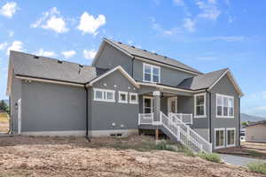 Rear view of property with covered porch