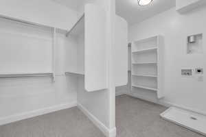 Spacious closet with light colored carpet