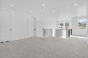 Spare room with an inviting chandelier, a textured ceiling, and light colored carpet