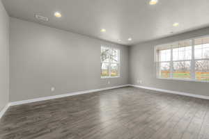 Spare room featuring a textured ceiling and dark hardwood / wood-style floors