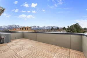 Deck featuring a mountain view and central air condition unit