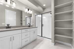 Bathroom featuring vanity and a shower with door