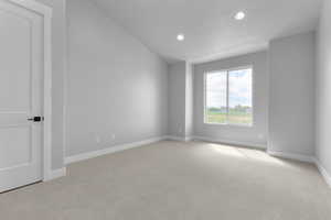 Carpeted empty room with vaulted ceiling